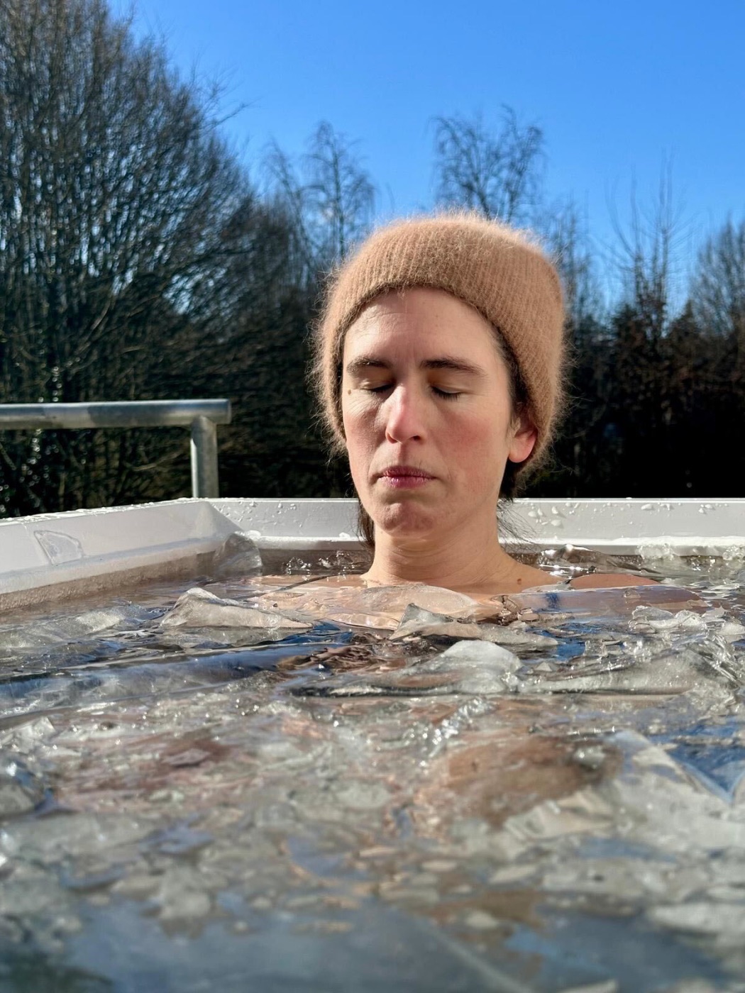 Frau beim Eisbad im zugefrorenen Becken